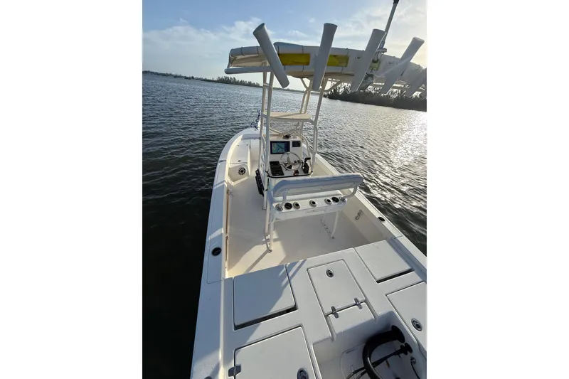 Slide: The Image of 2017 Pathfinder 2200 TRS boat on calm water, featuring a spacious deck and console. - 23