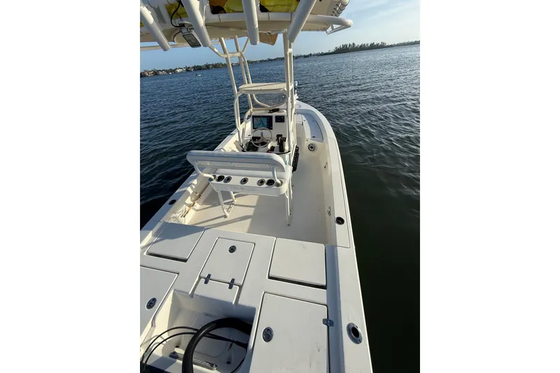 Slide: The Image of 2017 Pathfinder 2200 TRS boat on calm water, showcasing deck and seating area. - 25