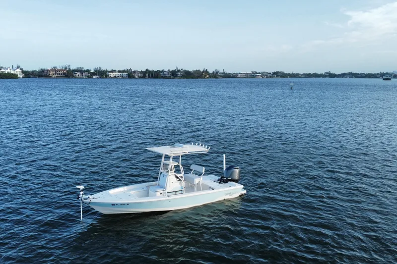 Slide: The Image of 2017 Pathfinder 2200 TRS boat on calm blue water with distant shoreline. - 3