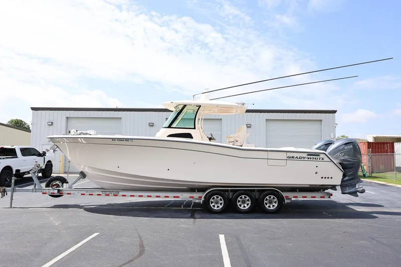 The Image of 2020 Grady-White Canyon 336 boat on trailer, parked outdoors near industrial buildings. - 1