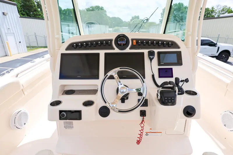 Slide: The Image of 2020 Grady-White Canyon 336 boat dashboard with steering wheel and electronic controls. - 15