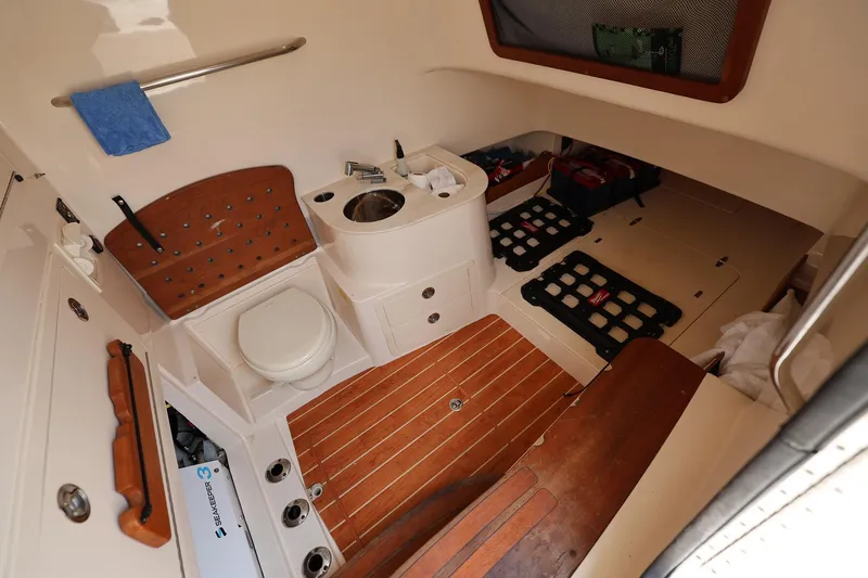 Slide: The Image of 2020 Grady-White Canyon 336 boat interior with toilet, sink, and wooden flooring. - 27