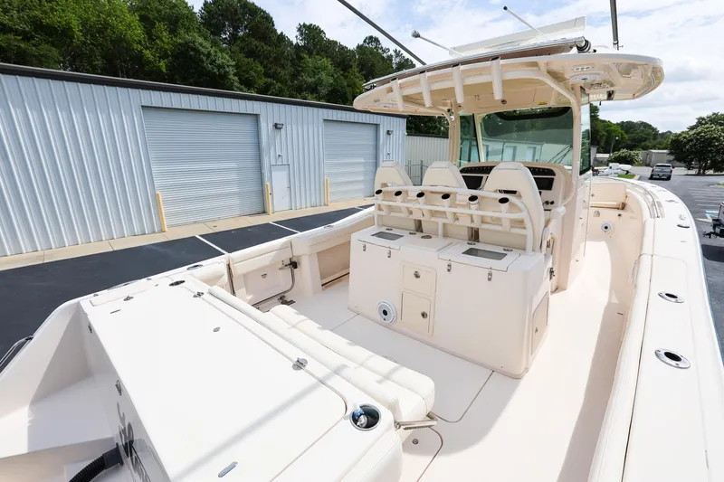Slide: The Image of 2020 Grady-White Canyon 336 boat with spacious deck and seating, parked near storage units. - 8