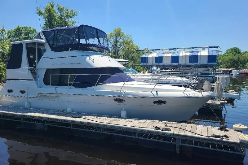 The Image of 2003 Carver 356 Aft Cabin Motor Yacht docked at marina under clear blue sky. - 1