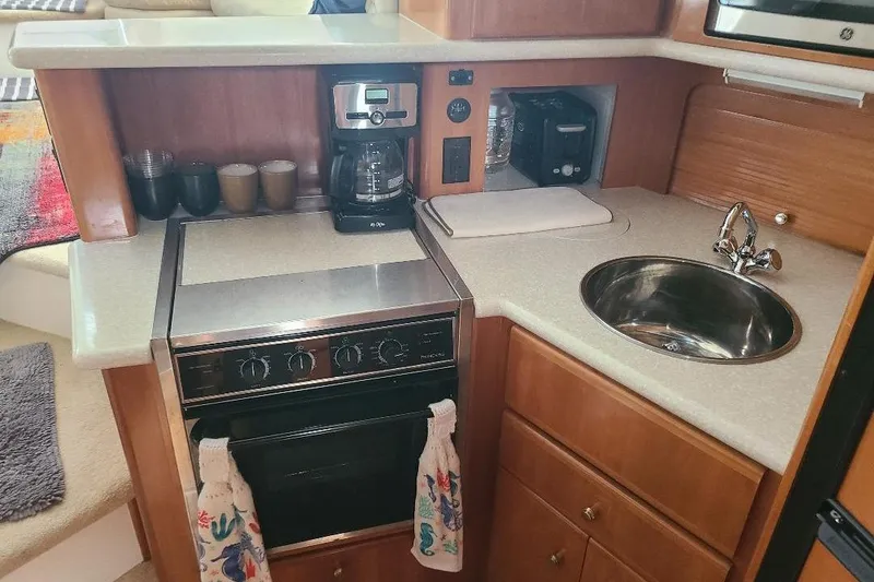 Slide: The Image of Compact kitchen in 2003 Carver 356 Aft Cabin Motor Yacht with stove, sink, and coffee maker. - 14