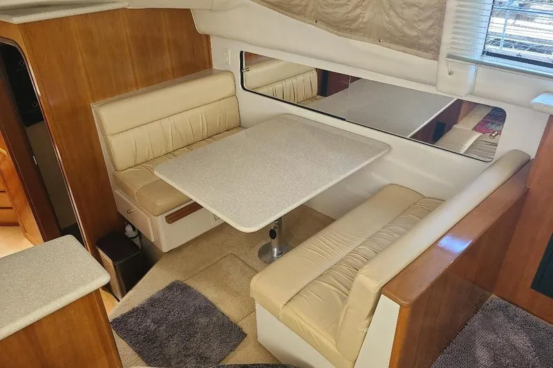 Slide: The Image of 2003 Carver 356 Aft Cabin Motor Yacht interior with beige seating and dining table. - 17