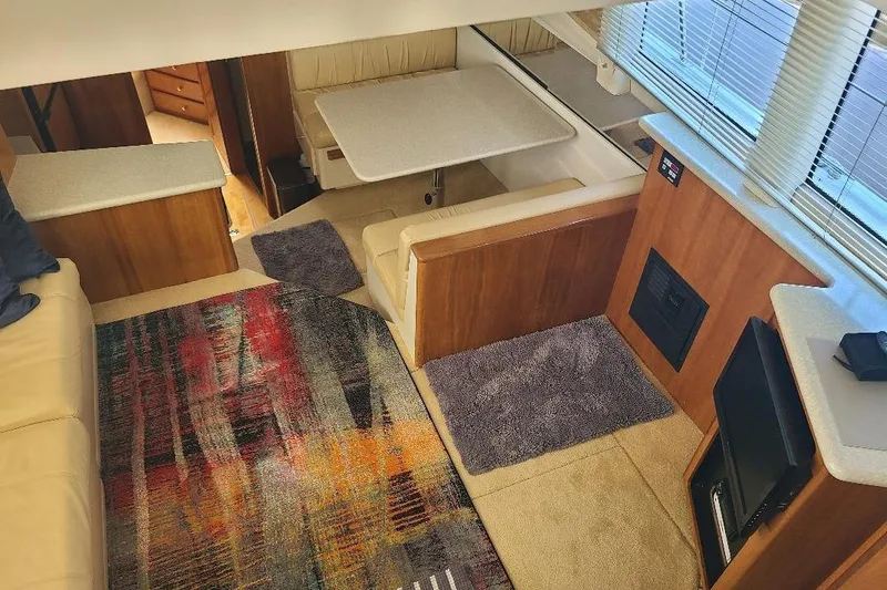 Slide: The Image of Interior of 2003 Carver 356 Aft Cabin Motor Yacht with cozy seating and colorful rug. - 20