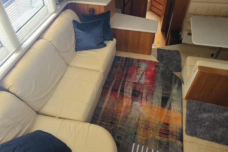 Slide: The Image of Interior of 2003 Carver 356 Aft Cabin Motor Yacht with beige seating and colorful rug. - 22