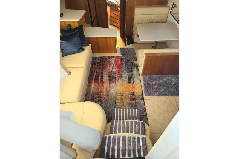 Slide: The Image of Interior of 2003 Carver 356 Aft Cabin Motor Yacht with cozy seating and colorful rug. - 24