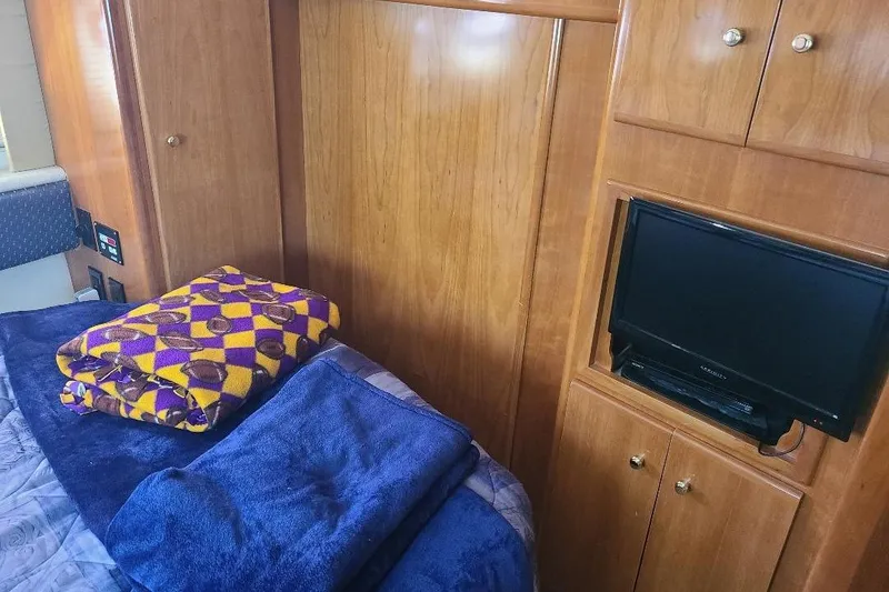 Slide: The Image of Interior of 2003 Carver 356 Aft Cabin Motor Yacht with TV and folded blankets. - 8
