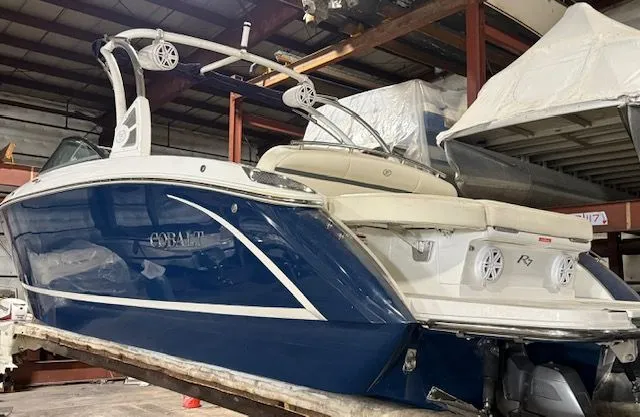 Slide: The Image of 2017 Cobalt R7 boat in warehouse, blue and white design. - 2