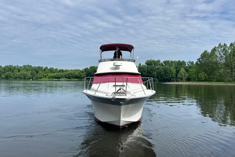 Slide: The Image of 1988 Silverton 34 Convertible boat on calm water, surrounded by lush greenery. - 2