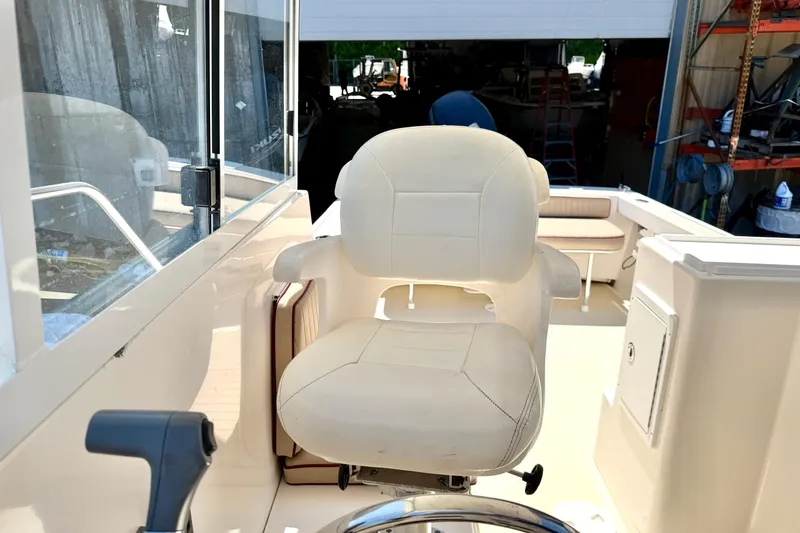 Slide: The Image of Captain's chair on 2007 NorthCoast 235 HT boat, featuring a spacious deck and helm controls. - 10