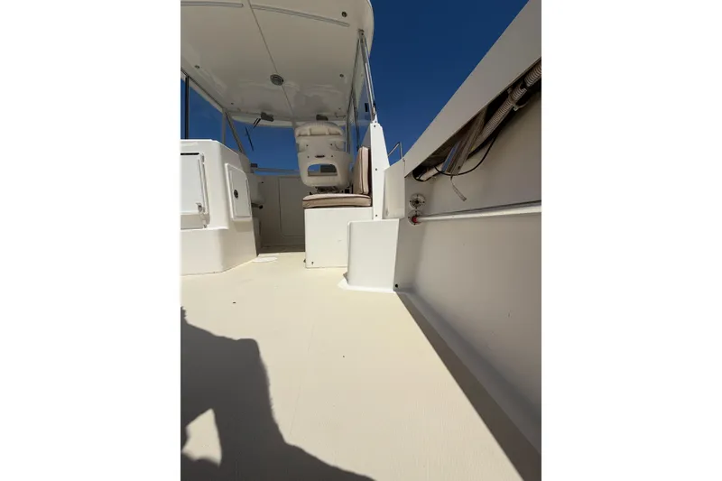 Slide: The Image of 2007 NorthCoast 235 HT boat interior, featuring seating and helm area under a clear blue sky. - 12