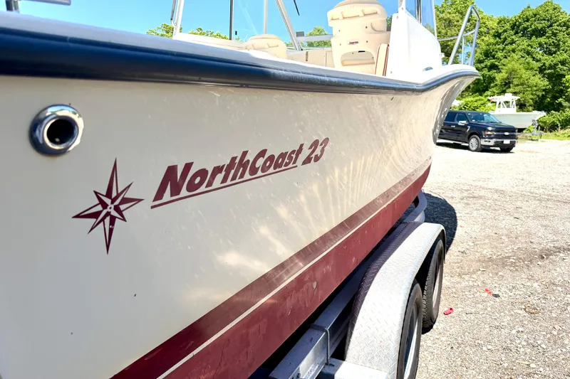 Slide: The Image of 2007 NorthCoast 235 HT boat on trailer, side view with logo and parked truck. - 2