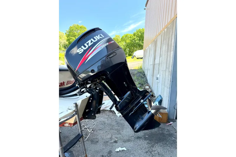 Slide: The Image of Suzuki outboard motor on 2007 NorthCoast 235 HT boat, parked outdoors. - 24