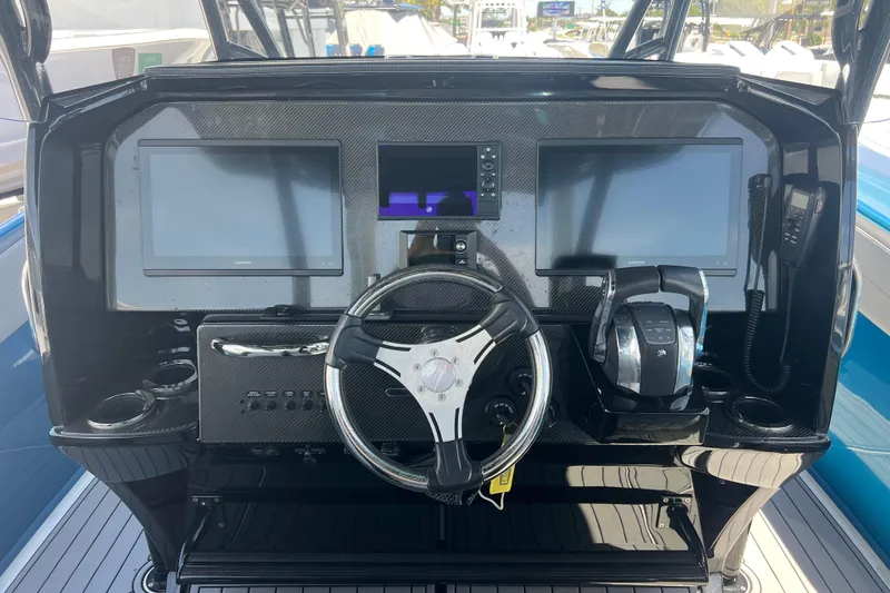 Slide: The Image of 2021 Nor-Tech 340 Sport Center Console dashboard with dual screens and steering wheel. - 11