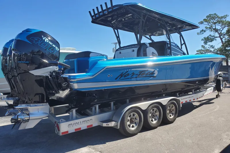 Slide: The Image of 2021 Nor-Tech 340 Sport Center Console boat on trailer, featuring Mercury 400 engines. - 3