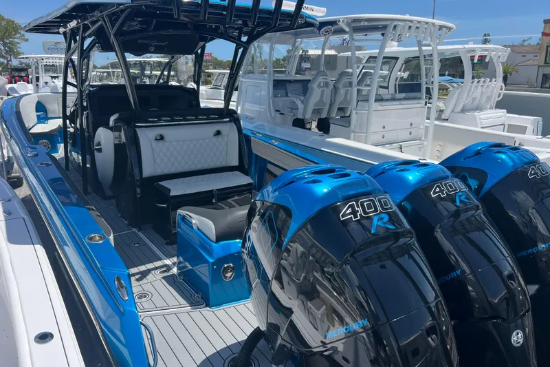 Slide: The Image of 2021 Nor-Tech 340 Sport Center Console boat with triple Mercury 400R engines, blue and white design. - 8