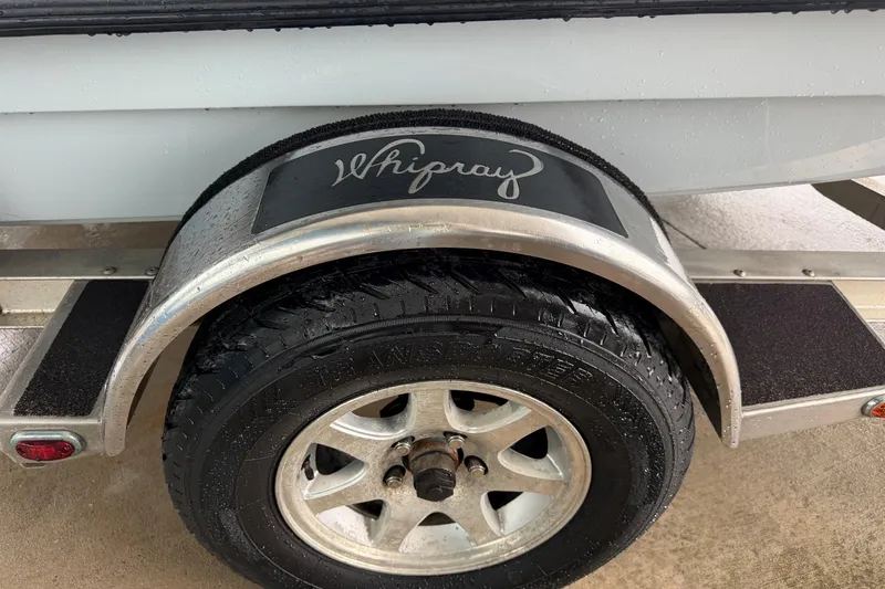 Slide: The Image of Trailer wheel of a 1999 Hell's Bay boat with "Whipray" branding. - 10
