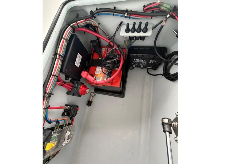 Slide: The Image of 1999 Hell's Bay boat electrical system with battery, wiring, and NOCO Genius charger. - 9