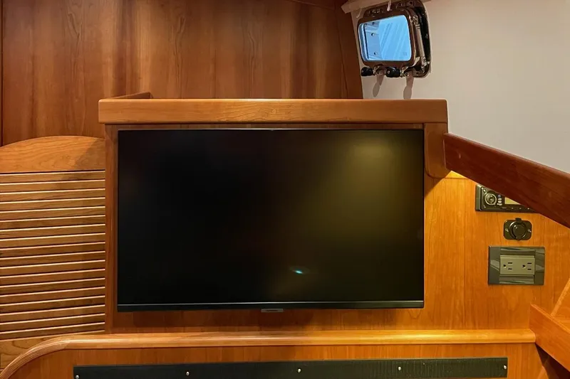Slide: The Image of Interior of 2016 Sabre 42 Salon Express with mounted TV and wooden paneling. - 10