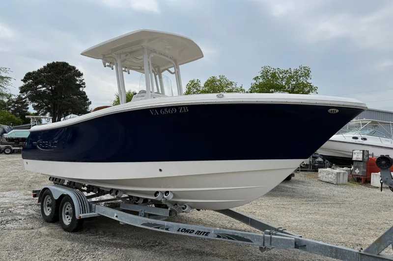 The Image of 2025 Robalo R232 Explorer boat on trailer, parked outdoors, side view. - 0
