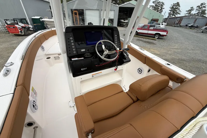 Slide: The Image of 2025 Robalo R232 Explorer boat interior with brown seating and modern dashboard. - 5