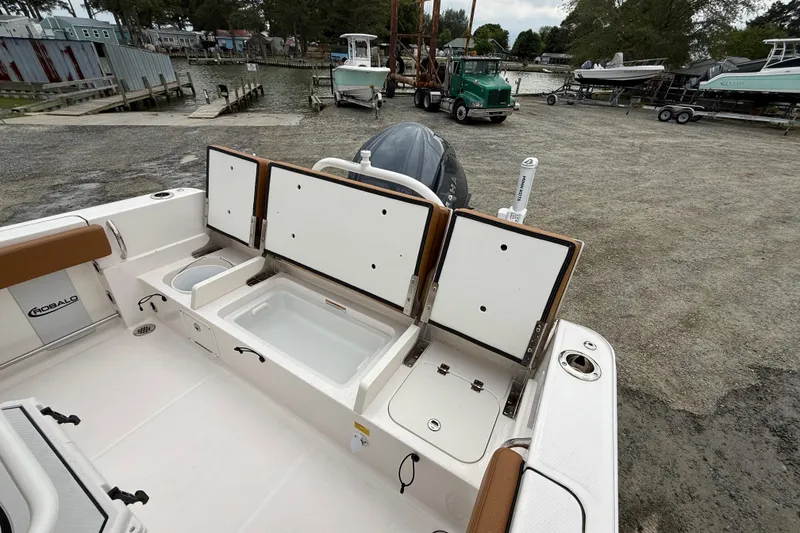 Slide: The Image of 2025 Robalo R232 Explorer with open storage compartments at dockside. - 6