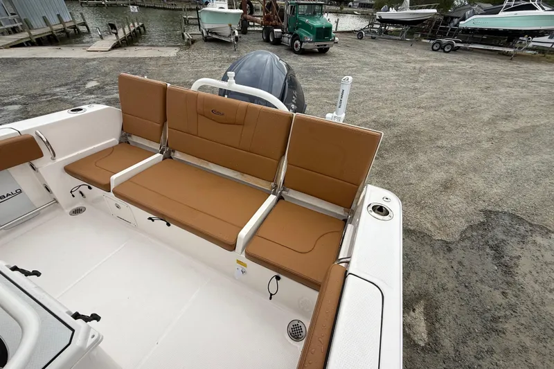 Slide: The Image of 2025 Robalo R232 Explorer with brown seats at the dock. - 7