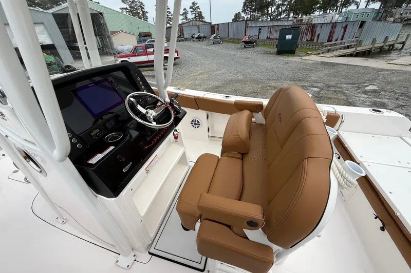 Slide: The Image of 2025 Robalo R232 Explorer boat interior with brown seating and modern dashboard. - 8