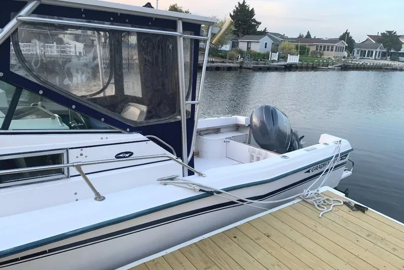 Slide: The Image of 1987 Grady-White Seafarer 226 boat docked by a serene waterfront. - 2