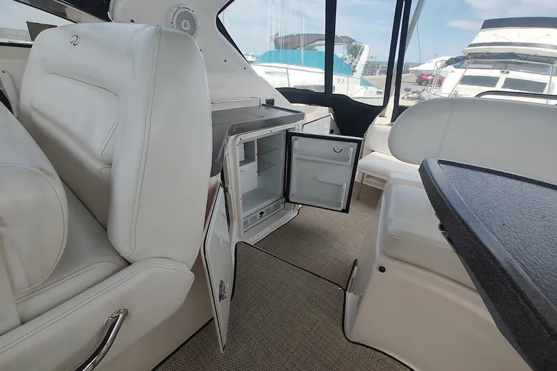 Slide: The Image of Interior of 2006 Regal Commodore 3560 IO yacht with open mini fridge and seating area. - 12
