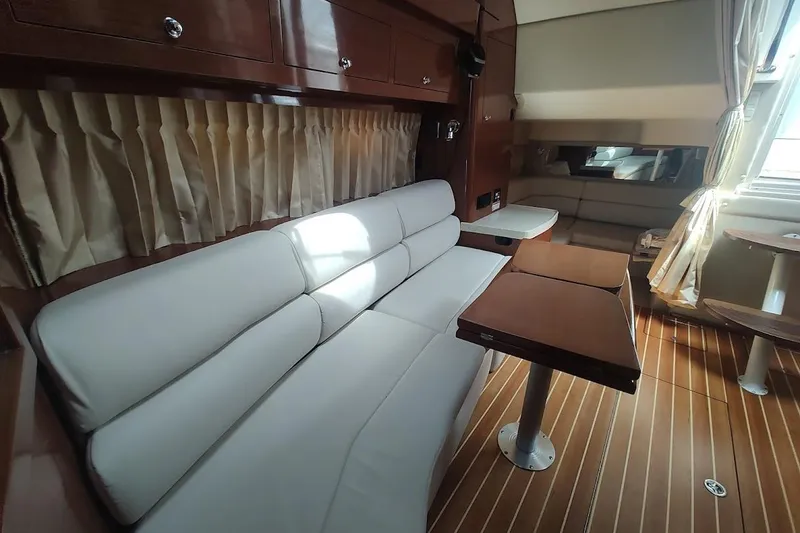 Slide: The Image of Interior of 2006 Regal Commodore 3560 IO yacht with white seating and wooden accents. - 17