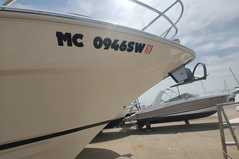 Slide: The Image of 2006 Regal Commodore 3560 IO boat docked, displaying registration number MC 0946SW. - 2