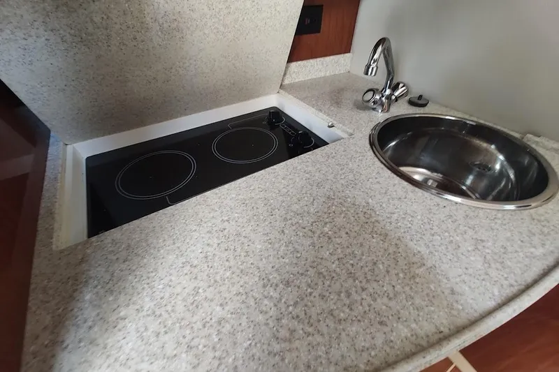 Slide: The Image of 2006 Regal Commodore 3560 IO yacht kitchen with stovetop and sink. - 22