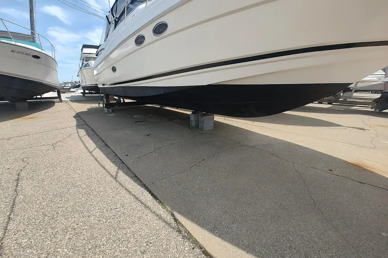 Slide: The Image of 2006 Regal Commodore 3560 IO yacht on dry dock, showcasing sleek hull design. - 3