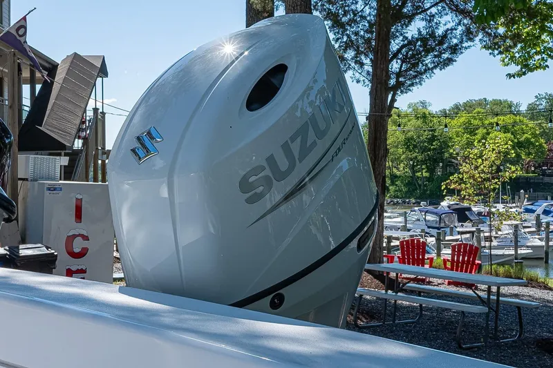 Slide: The Image of Outboard motor on 2026 Privateer 2100 Roamer boat, marina background, sunny day. - 10