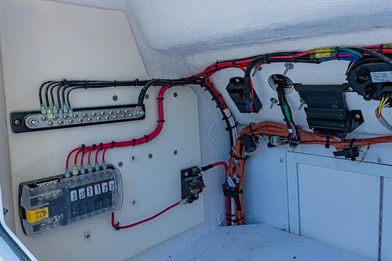 Slide: The Image of Electrical wiring setup in a 2026 Privateer 2100 Roamer boat, showcasing organized cables and connectors. - 13
