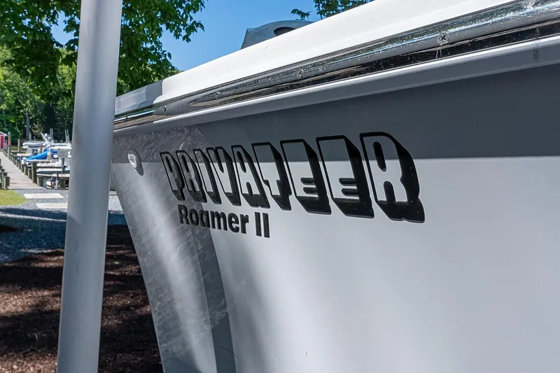 Slide: The Image of 2026 Privateer 2100 Roamer boat docked, showcasing sleek design and branding. - 15