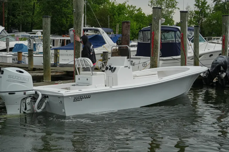 Slide: The Image of 2026 Privateer 2100 Roamer boat docked, featuring Suzuki outboard motor. - 16