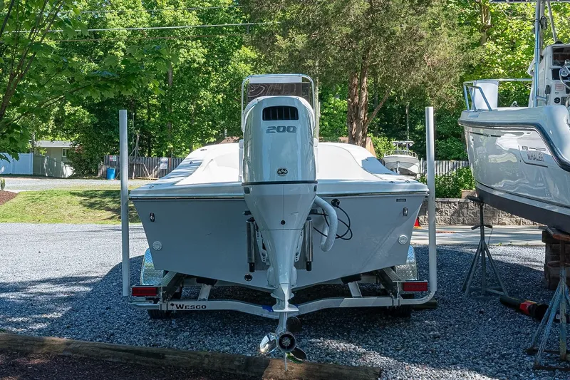 Slide: The Image of 2026 Privateer 2100 Roamer boat on trailer, surrounded by greenery and parked boats. - 3