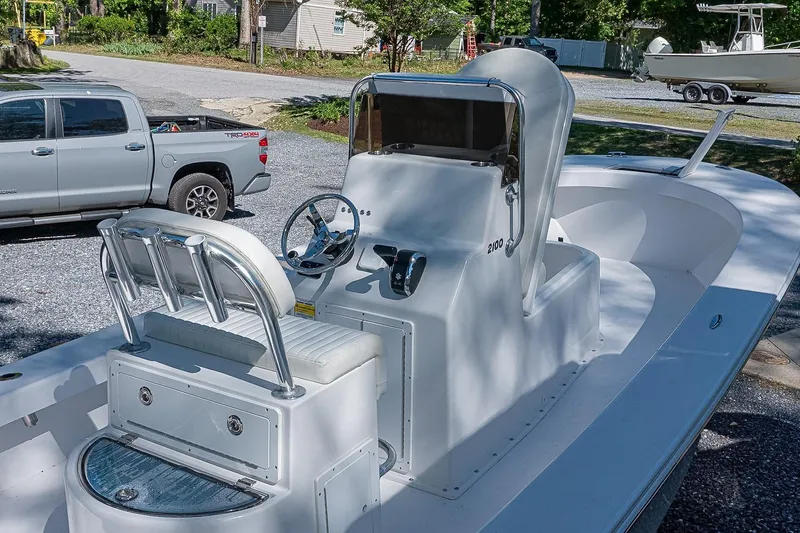Slide: The Image of 2026 Privateer 2100 Roamer boat with sleek design, parked near a pickup truck. - 4