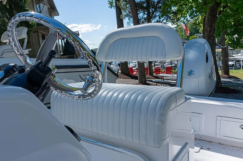 Slide: The Image of Interior of 2026 Privateer 2100 Roamer boat with white seating and chrome steering wheel. - 8