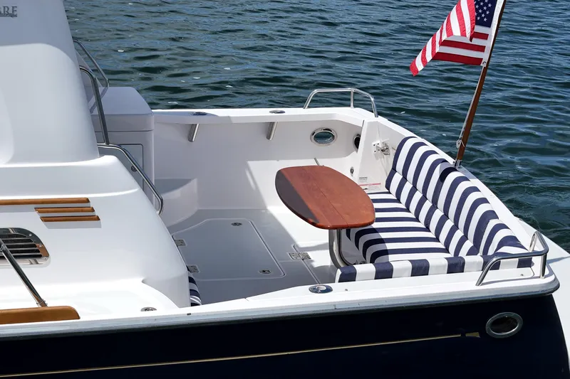 Slide: The Image of 2015 Sabre 42 Salon Express yacht with striped seating and American flag on water. - 22