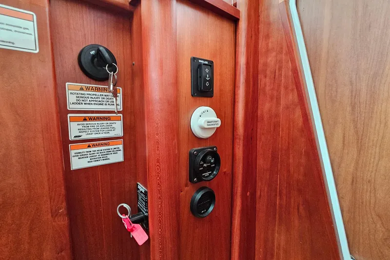 Slide: The Image of Control panel on 2015 Sabre 42 Salon Express yacht with warning labels and switches. - 35