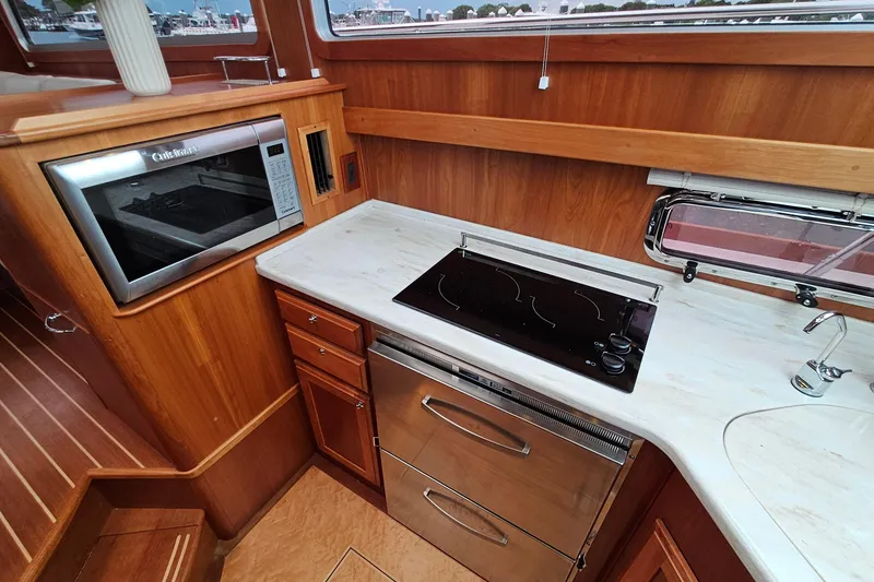 Slide: The Image of Galley kitchen in 2015 Sabre 42 Salon Express with stove, microwave, and wood cabinetry. - 41