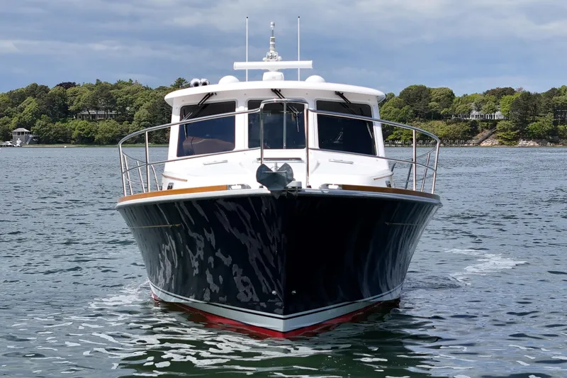 Slide: The Image of 2015 Sabre 42 Salon Express yacht on calm water, surrounded by lush greenery. - 7