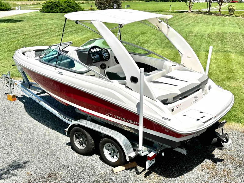 The Image of 2019 Regal 2000 ES Bowrider boat on a trailer in a grassy area. - 0