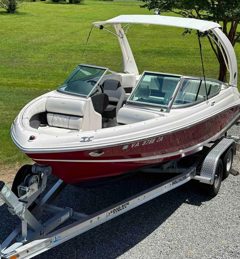 Slide: The Image of 2019 Regal 2000 ES Bowrider boat on trailer, red and white, parked on gravel. - 3